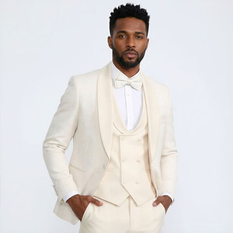 Man wearing a ivory tuxedo against a plain background