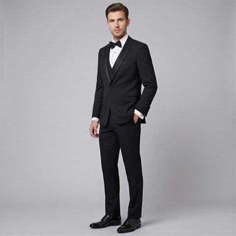 Man wearing a black tuxedo on a gray background