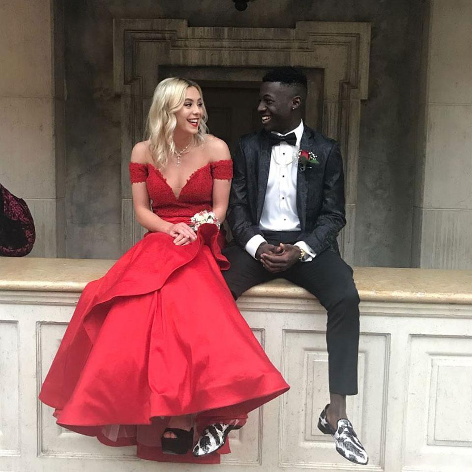 prom couple with guy wearing black prom suit jacket